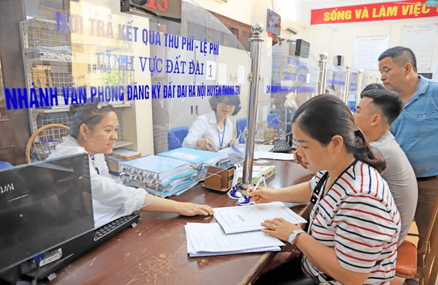 Người dân đang làm thủ tục hành chính liên quan đến đất đai tại Văn phòng Đăng ký đất đai