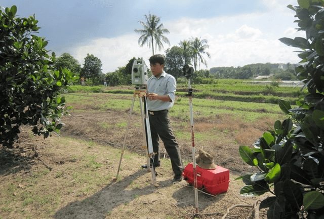 Kỹ sư đang sử dụng máy GPS RTK để cắm mốc ranh giới đất đai tại một công trình